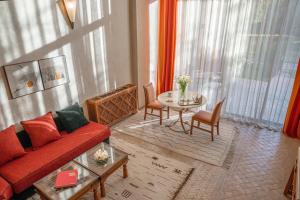 a living room with a red couch and a table at Es Saadi Marrakech Resort - Palace in Marrakesh +78 photos