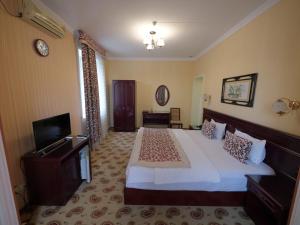 a bedroom with a large bed and a television at Asia Hotel Fergana in Fergana