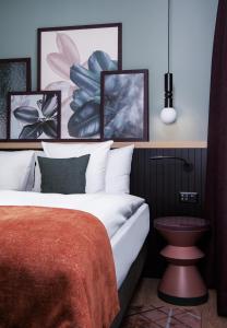 a bedroom with a bed and pictures on the wall at Sorell Boutique-Hotel St Peter Zürich in Zurich