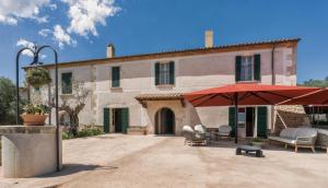 a large building with a red umbrella in front of it at Son Sabater by Zafiro in Sa Pobla