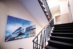 a staircase with a large picture of buildings on the wall at Sorell Hotel Rex Zürich in Zurich