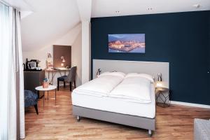 a bedroom with a white bed and a blue wall at Sorell Hotel Rex Zürich in Zurich +23 photos