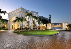 a building with palm trees in front of it at Sandals Royal Bahamian All Inclusive Adults Only in Nassau