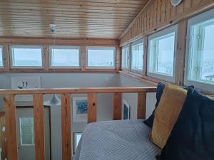 a room with a bed in a cabin with windows at Lumikko Aurora Loft in Enontekiö