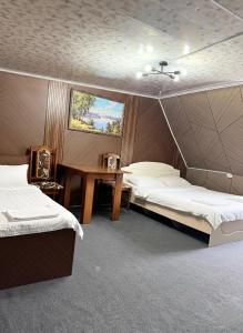 a room with two beds and a desk in a tent at Timur Resort Turgen in Taūtürgen