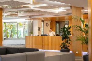 a man talking on a phone in an office lobby at Invisa Hotel Es Pla - Adults Only in San Antonio