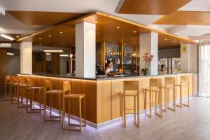 a bar with a row of stools in a restaurant at Invisa Hotel Es Pla - Adults Only in San Antonio