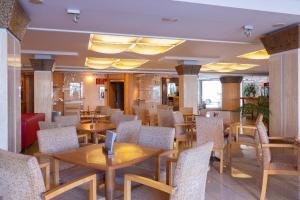 a restaurant with wooden tables and chairs at Invisa Hotel La Cala in Santa Eularia des Riu