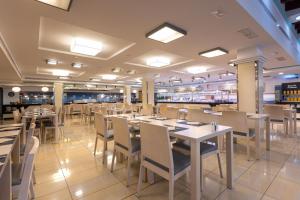 a dining room with tables and chairs in a restaurant at Invisa Hotel La Cala in Santa Eularia des Riu +27 photos