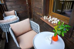 a table and chairs on a balcony with a vase with a plant at Effect Boutique Villa Azzura - Adults Only SELF CHECK-IN in Nesebar