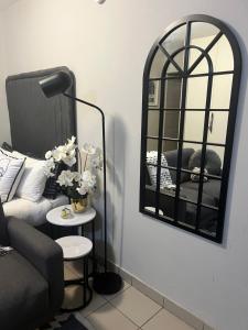 a living room with a couch and a mirror at B-Hive at Devland Room 3 in Soweto