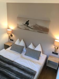 a bedroom with a bed with a picture on the wall at Appartement Sunside in Saalbach-Hinterglemm