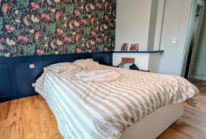 a bedroom with a bed with a floral wallpaper at Le Saint-Georges in Berck-sur-Mer