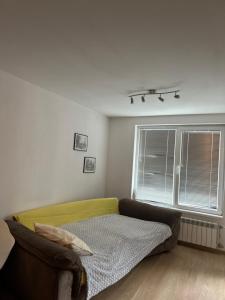 a living room with a couch and a window at GALAXY apartment in Sofia