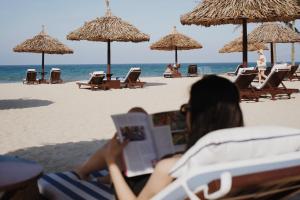 a woman laying on the beach reading a book at Furama Resort Danang in Danang