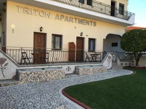 a building with a sign that reads tuition apartmentments at Triton Apartments in Nea Skioni