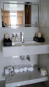 a white bathroom with a sink and a mirror at Khách Sạn Ngọc Châu in Lấp Vò +17 photos