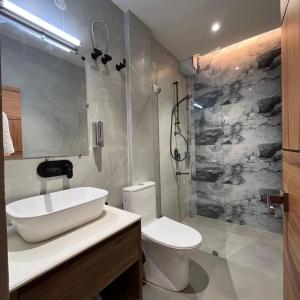 a bathroom with a sink and a toilet and a shower at Konwar Inn & Suites in Golāghāt +7 photos