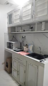 a kitchen with white cabinets and a sink at Jessa's Transient Studio with Balcony in Masbate