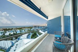 a balcony with chairs and a view of the ocean at Sueno Hotels Deluxe Belek in Belek