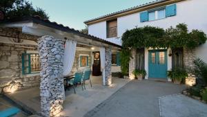 a house with a blue door and a patio at Villa Buby by Villas Guide in Kraljevica