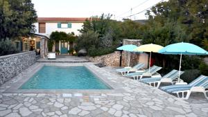 a swimming pool with lounge chairs and umbrellas at Villa Buby by Villas Guide in Kraljevica