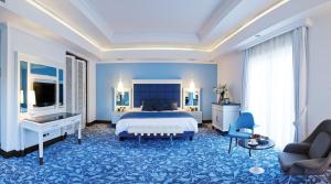 a bedroom with a king sized bed and a blue carpet at Azure Villas By Cornelia in Belek +69 photos