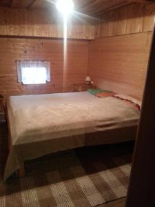 a bedroom with a large bed in a wooden room at Ahnenhütte Untersabernighof in Penk