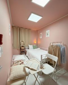 a room with two beds and a table and chairs at 자자쿨스테이 in Seoul