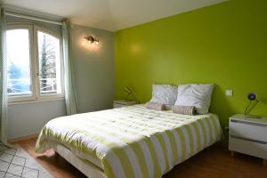 a green bedroom with a bed and a window at Villa Au petit baigneur - Maison avec piscine et jardin clos in Challans +15 photos