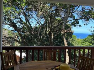 a table on a balcony with a view of the ocean at Vista Alta Serma in Ponta Malangane