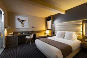 a hotel room with a bed and a desk at Hôtel de Brienne in Toulouse +99 photos