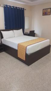 a large bed in a room with a blue curtain at AB Residency in Chennai