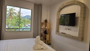 a bedroom with a bed and a tv and a window at SilverLeaf in El Nido