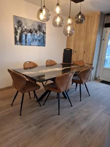 a dining room table with chairs and a laptop on it at Lichtrijk en comfortabel hoekappartement met gratis parking en zeer centraal gelegen - Comme Chez Soi in Ostend