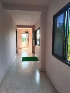 an empty hallway with a window and a green rug at Krabi Hotel Agency in Krabi