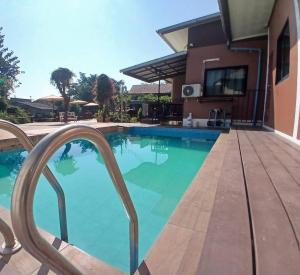 a swimming pool in front of a house at River Bend Villas in Mae Rim