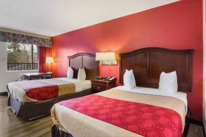 two beds in a hotel room with red walls at Econo Lodge Williamsburg Historic Area in Williamsburg