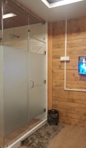 a shower with a glass door in a bathroom at Ribhoi Jungle in Khānāpāra