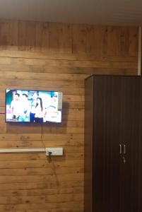 a flat screen tv on a wooden wall at Ribhoi Jungle in Khānāpāra