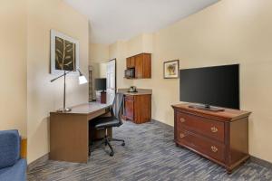 a hotel room with a desk with a computer and a tv at Country Inn & Suites by Radisson, Des Moines West, IA in Clive