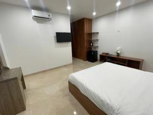 a bedroom with a bed and a television in it at Hải Nam Hotel Tây Ninh in Tây Ninh