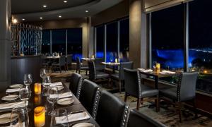 a restaurant with tables and chairs with a view at The Brock Niagara Falls Fallsview, Tapestry by Hilton in Niagara Falls +51 photos