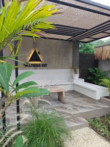 a patio with a bench under a pergola at GHangga Amed in Karangasem
