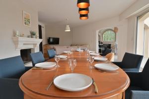 a long table with plates and wine glasses on it at Villa Au petit baigneur - Maison avec piscine et jardin clos in Challans
