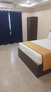 a bedroom with a large bed with blue curtains at AB Residency in Chennai