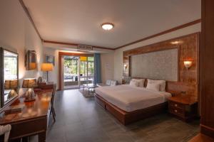 a hotel room with a bed and a desk and a desk at Erawan Phangnga Hotel, Natai Beach in Ban Na Phong
