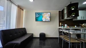 a living room with a couch and a kitchen at Apartamentos Santiago Centro R&M in Santiago