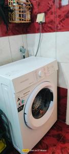 a washing machine in a room with a red wall at EvropisHouse in Kozani