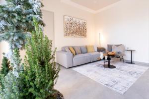 a living room with a couch and a christmas tree at Waldhotel Hohe Sonne Eisenach in Eisenach +15 photos